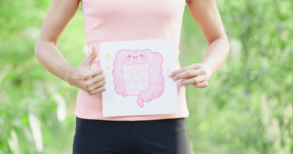 frau hält Blatt Papier mit Darm vor den Bauch