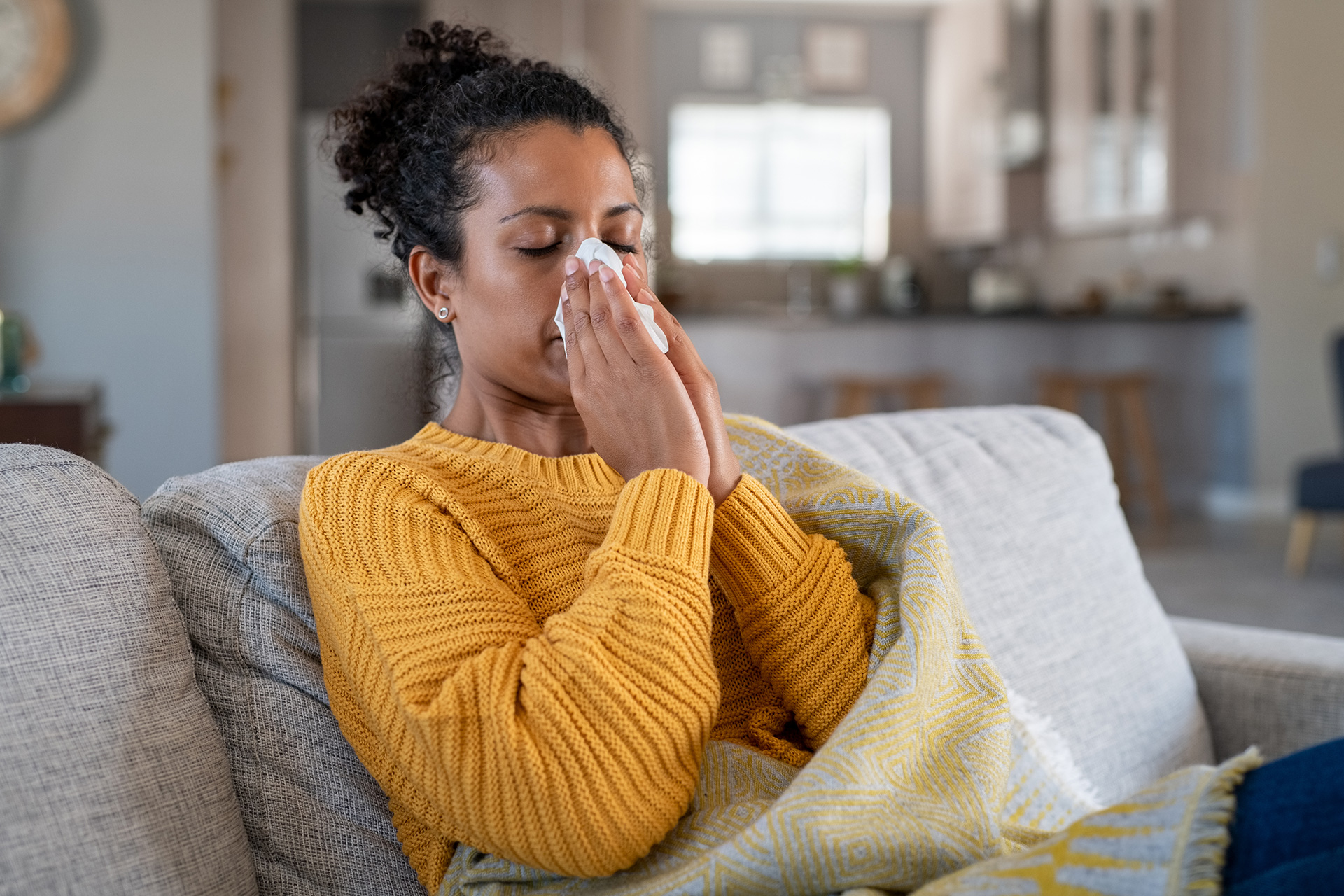 junge Frau schnäubt ihre Nase in Taschentuch