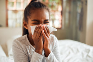 Allergietests für Kinder: junges Mädchen schnäubt Nase