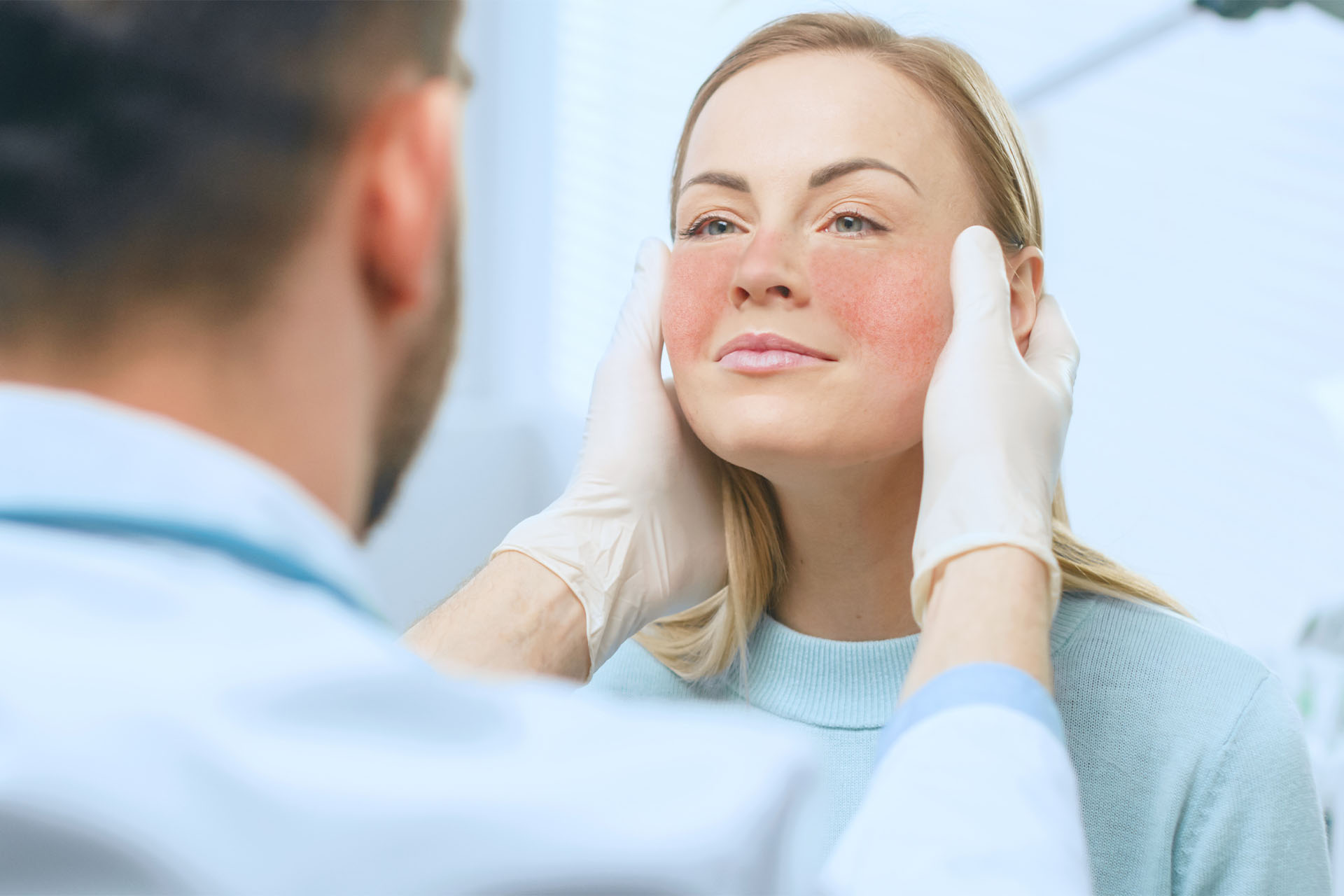 Arzt untersucht Frau mit Rosacea